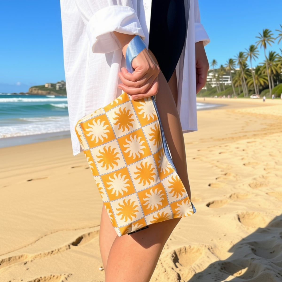 Golden Rays pouch hanging from its wrist strap at the beach