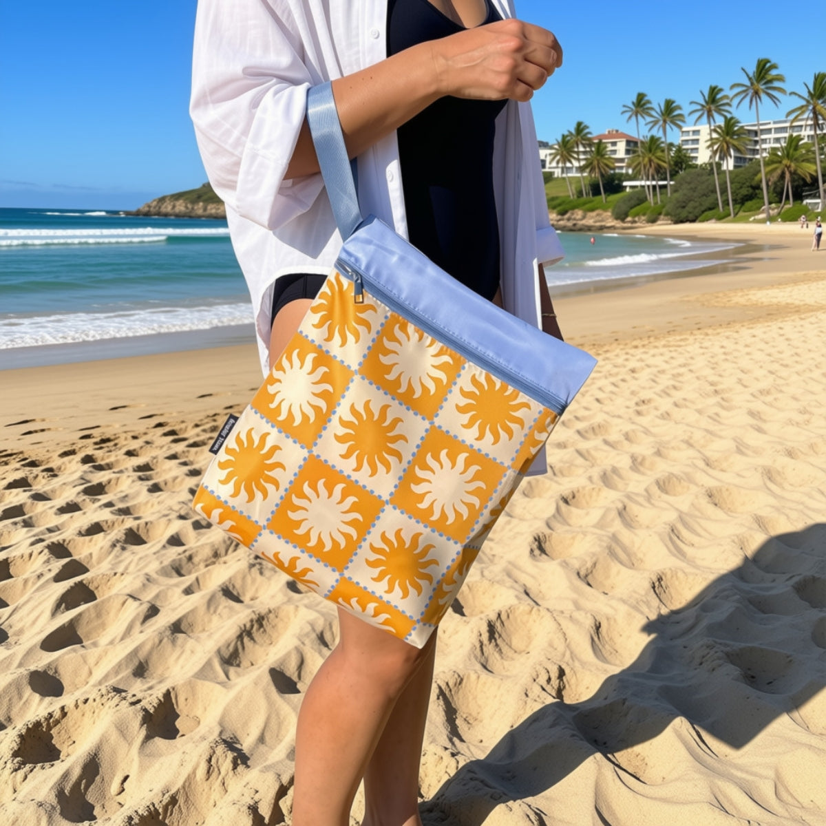 Golden Rays wet bag hanging off an arm at the beach